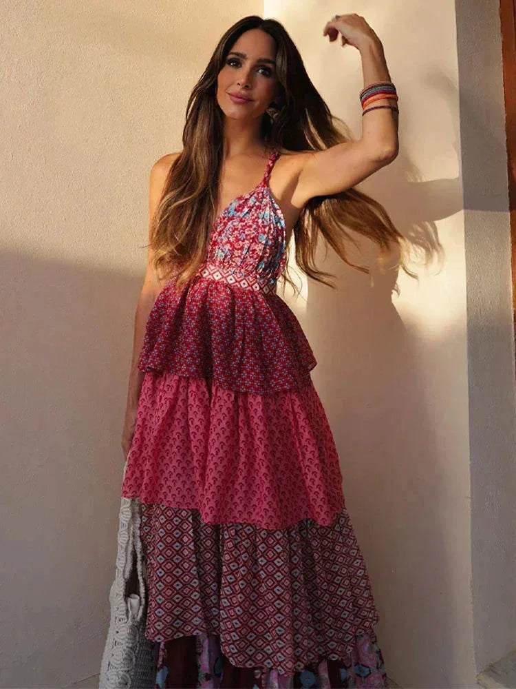 Robe longue sans manches rouge et rose, en tissu léger, avec volants multiples, idéale pour des journées estivales.