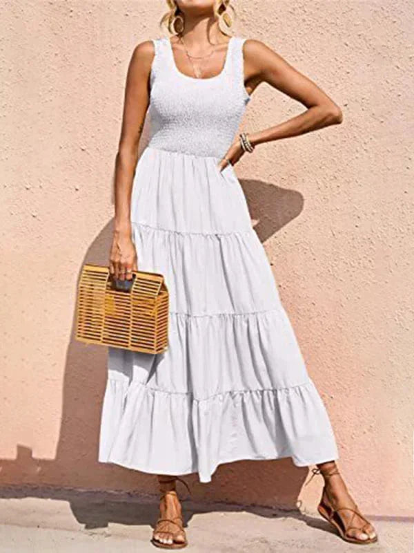 Robe longue sans manches en tissu léger, smockée à la taille avec des volants, idéale pour les journées d'été.