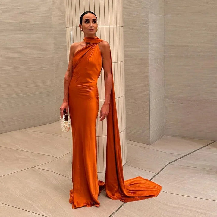 Robe satinée épaule unique avec cape, parfaite pour soirées, offrant une silhouette élégante et un tissu fluide.