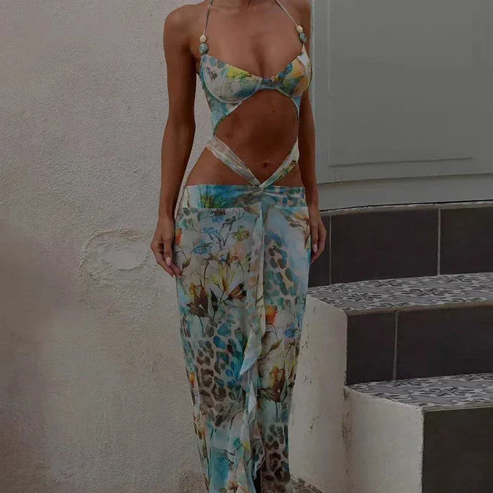 Robe longue turquoise avec motif fleuri, découpe moderne, en tissu léger, idéale pour l'été, avec bretelles fines.