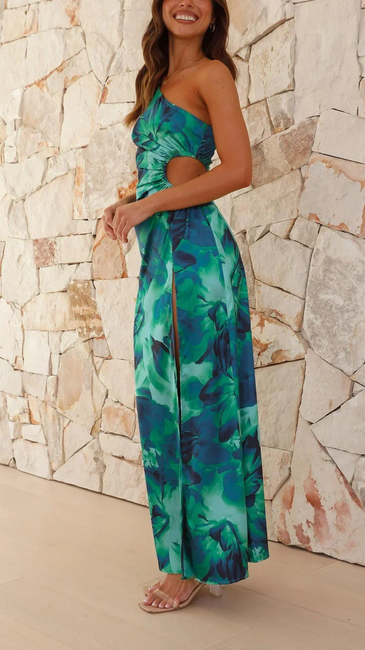 Robe longue verte à une épaule, fente latérale, en tissu léger, ornée d'un imprimé floral coloré.