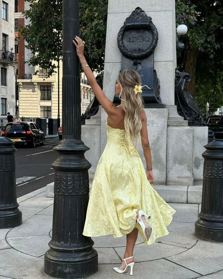 Robe midi jaune à dos nu, jupe plissée en tissu léger, idéale pour les soirées d'été.