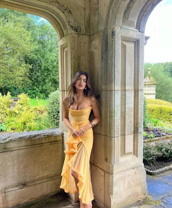 Robe midi ajustée en coton, avec volants délicats et bretelles fines, parfaite pour les journées ensoleillées.