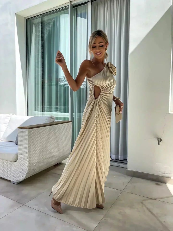 Robe midi asymétrique en tissu plissé, avec découpe sculptée et teinte rose douce, idéale pour une tenue élégante.