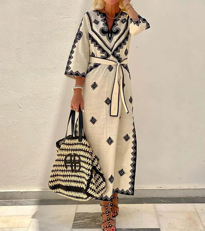Robe midi beige en tissu léger, imprimée, ceinture à la taille, manches 3/4 et col en V, idéale pour l'été.