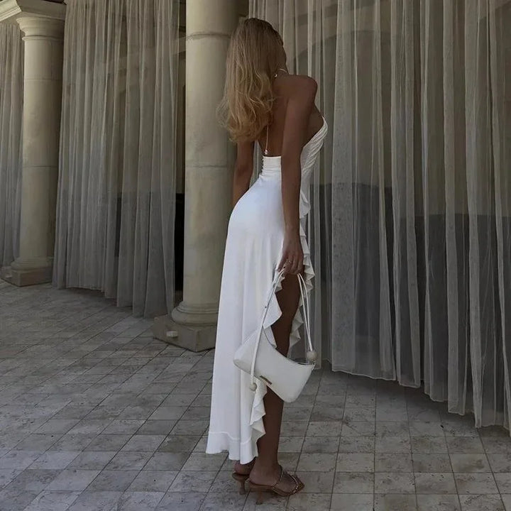Robe midi blanche asymétrique sans manches en tissu fluide avec col licou et volants pour soirées d'été.
