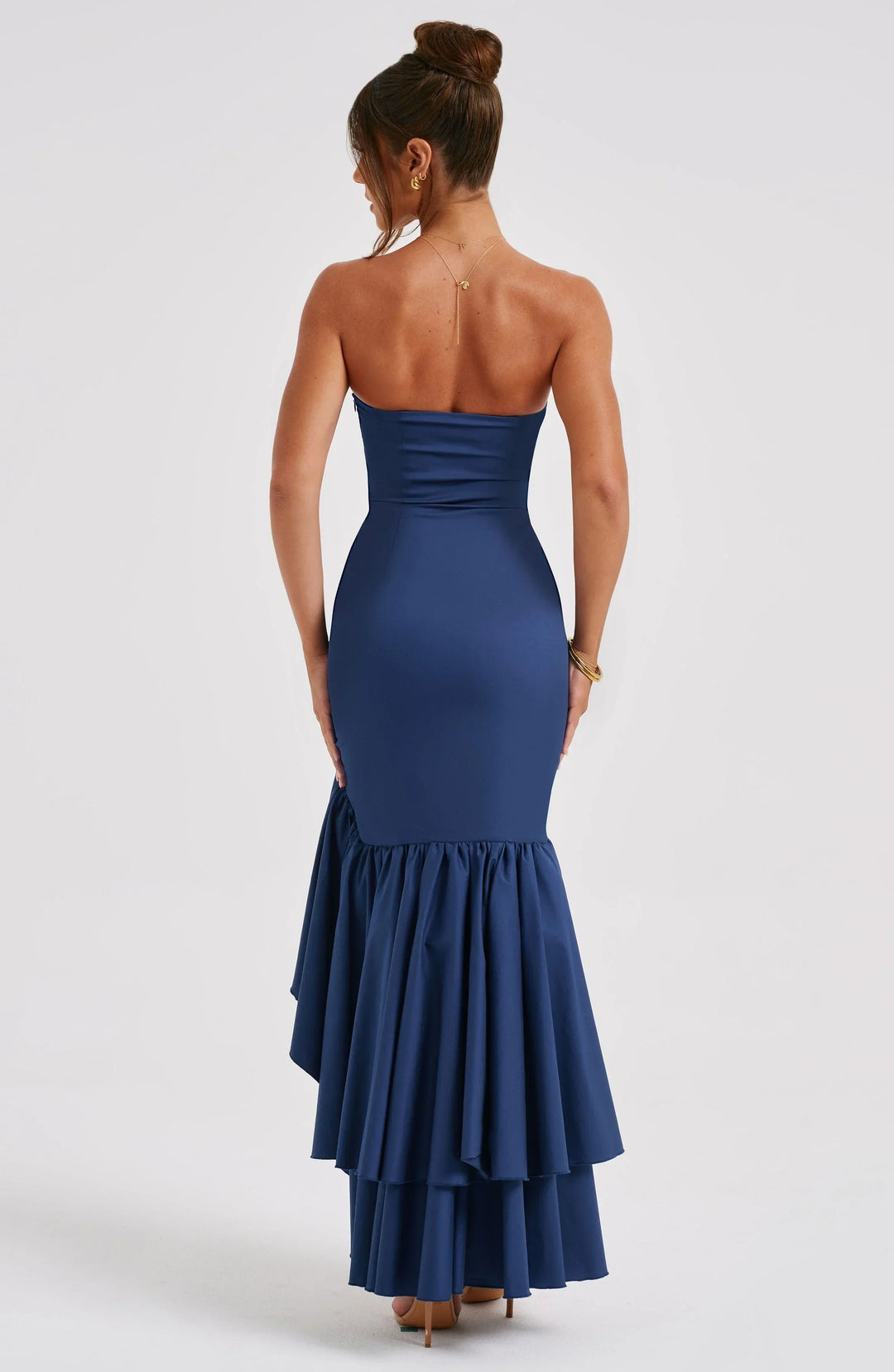Robe midi bustier en tissu léger avec jupe à volants asymétriques, idéale pour des soirées élégantes.