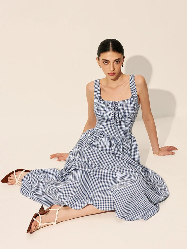 Robe midi sans manches à carreaux bleu marine, col carré, en tissu léger, idéale pour les journées d'été décontractées.