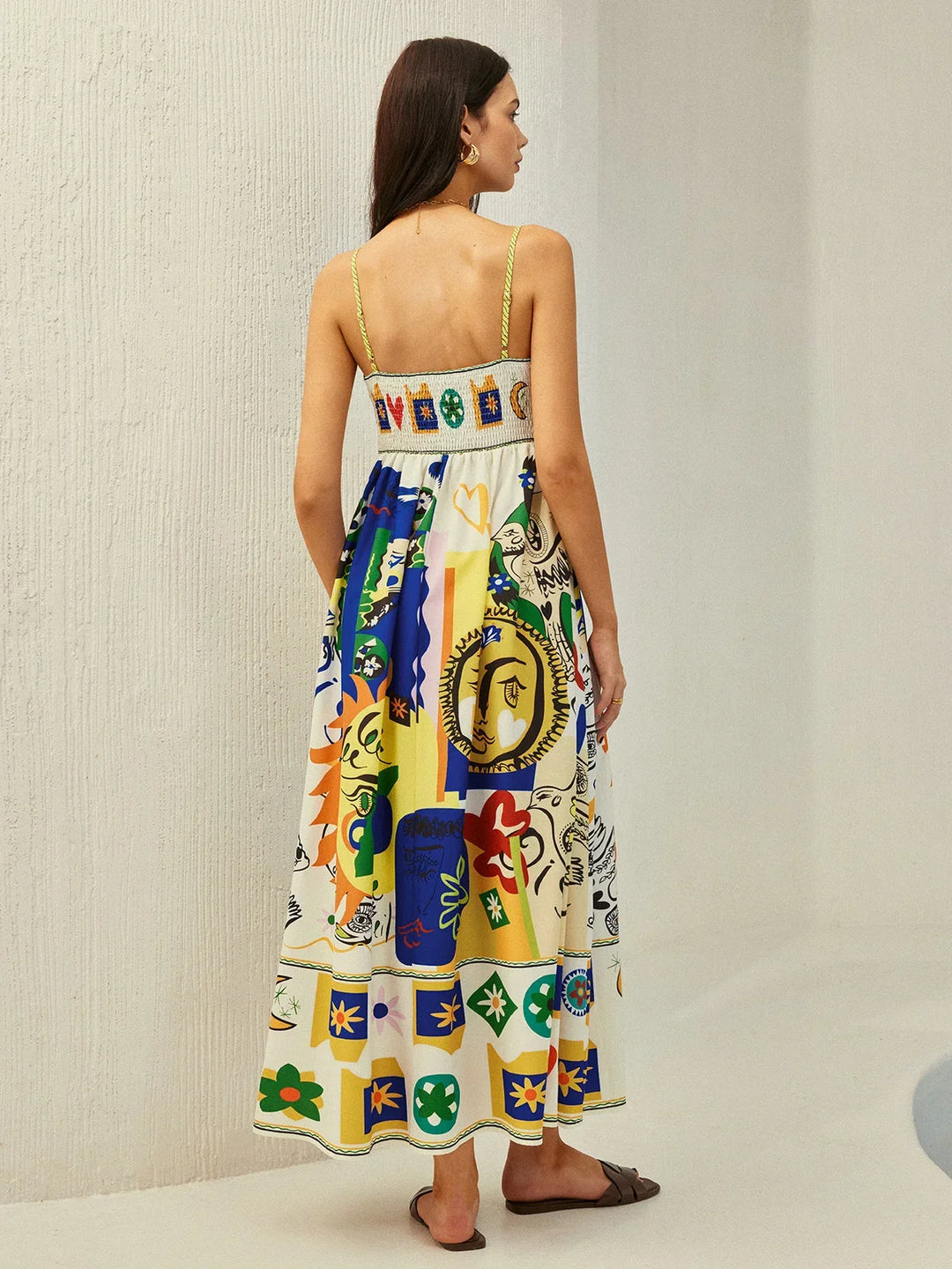 Robe midi colorée avec motifs ludiques, bretelles fines en tissu fluide parfait pour les journées ensoleillées.