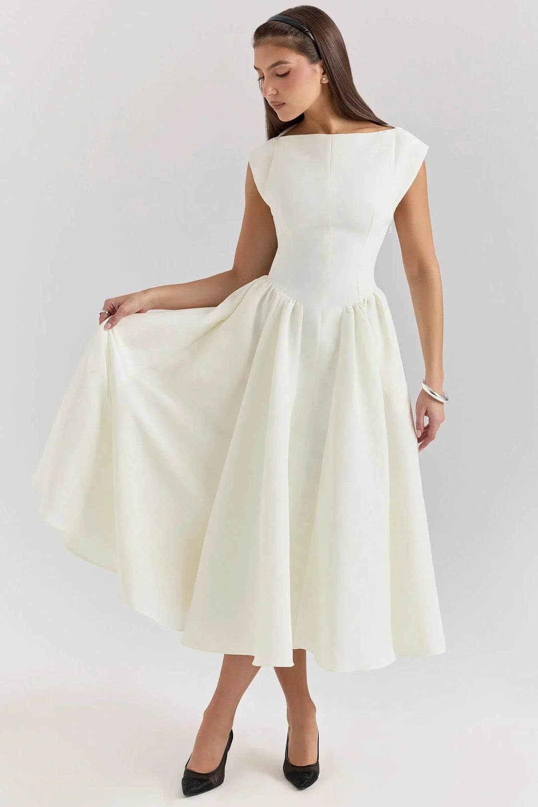 Robe midi sculptée, manches courtes, col rond, en tissu léger avec jupe ample, idéale pour les soirées estivales.