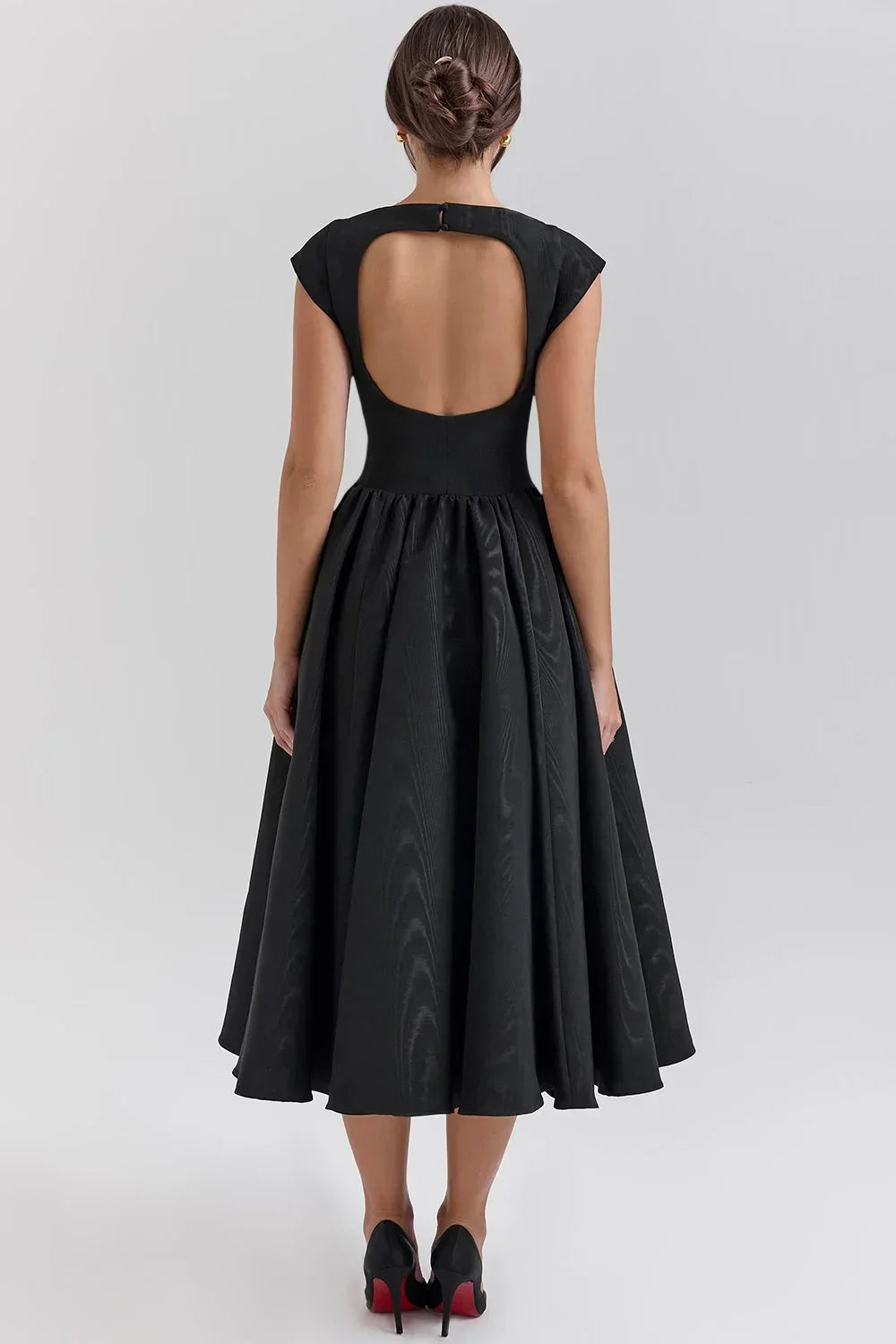 Robe midi sculptée en tissu fluide avec manches courtes, col rond, et jupe ample, idéale pour les soirées élégantes.