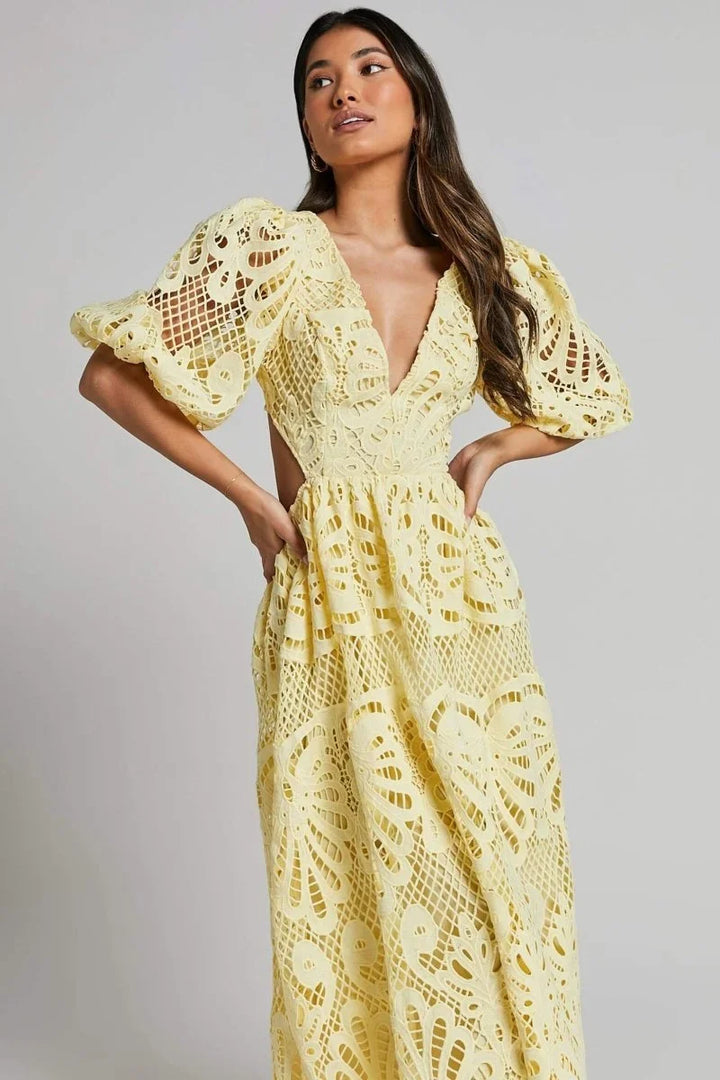Robe midi en dentelle, col en V, avec des manches bouffantes et une coupe fluide, idéale pour les occasions spéciales.