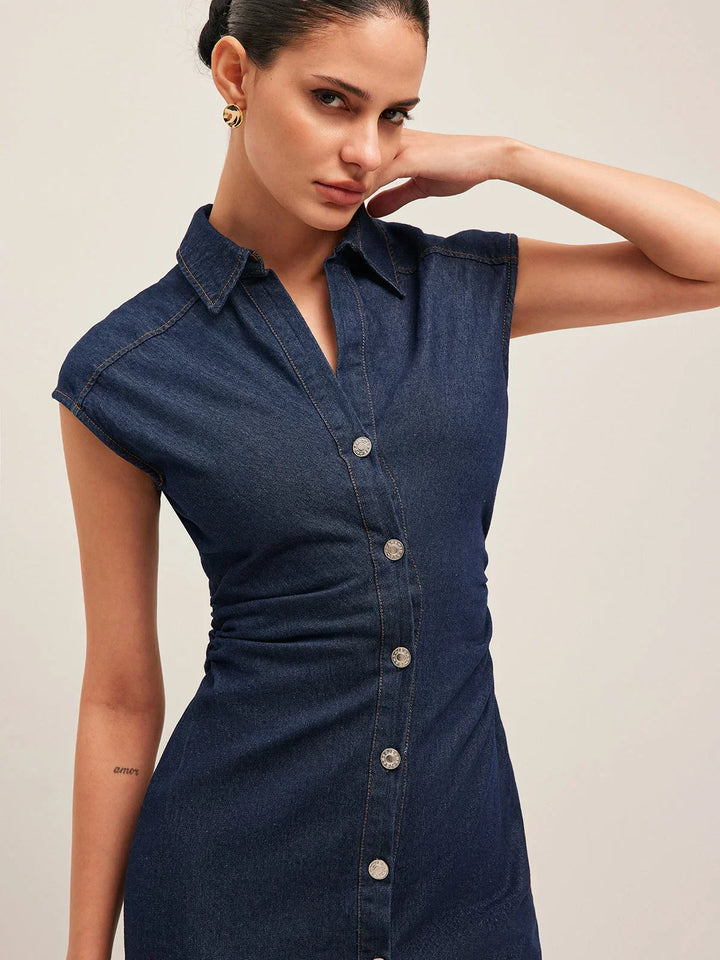 Robe midi en jean bleu foncé, sans manches, col V, avec des boutons sur le devant pour un look décontracté.