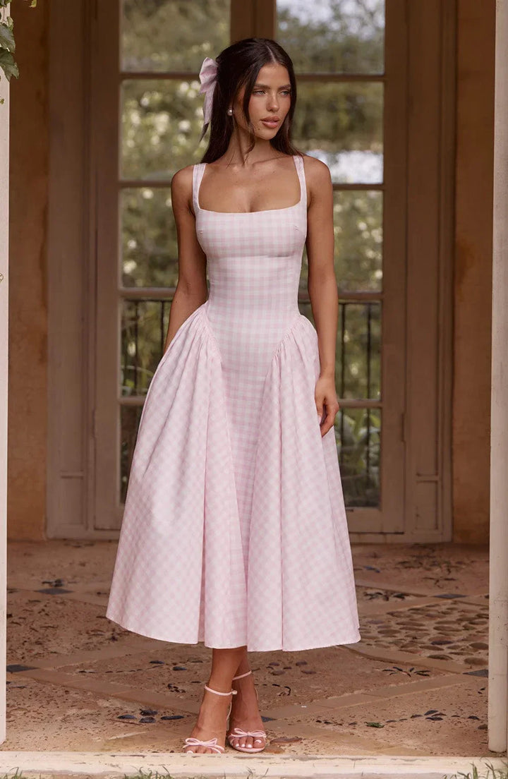Robe midi femme sans manches en tissu à carreaux, avec une coupe élégante et légère, idéale pour les journées estivales.