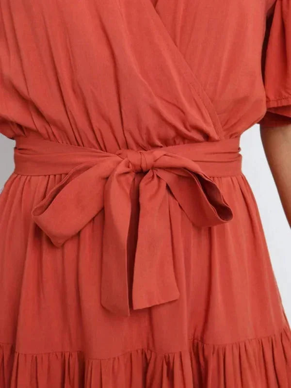 Robe midi femme en tissu léger, ceinturée avec volants, col en V et manches courtes pour un look décontracté et élégant.