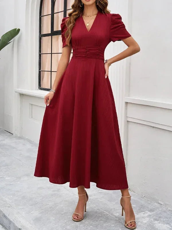 Robe midi femme avec col V, manches bouffantes, en tissu léger à motifs floraux, idéale pour les journées printanières.