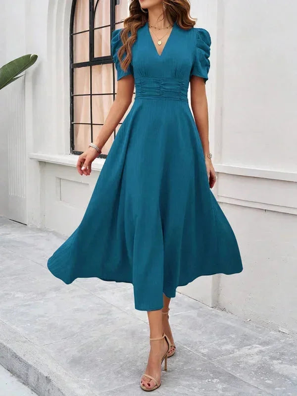 Robe midi femme en bleu, col V, manches bouffantes, tissu léger et fluide parfait pour le printemps.