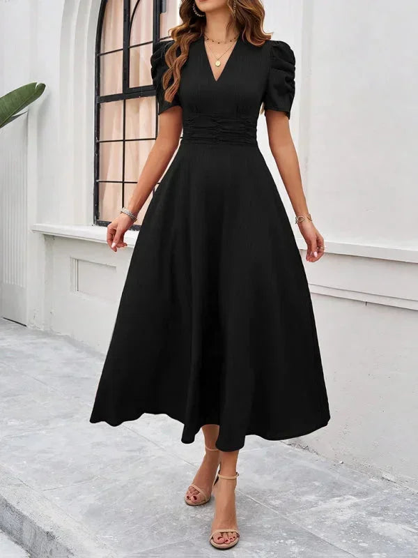 Robe midi femme col V en noir, avec manches bouffantes et tissu léger, parfaite pour un style décontracté et élégant.