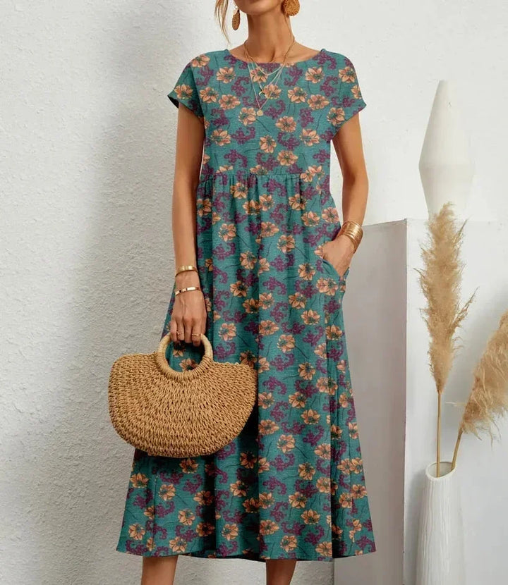 Robe midi en coton bleu avec imprimé floral, dotée de poches pratiques et d'une coupe élégante pour le confort quotidien.