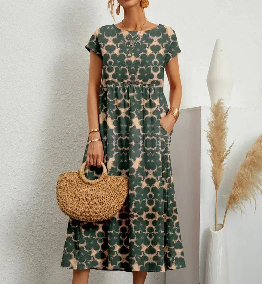 Robe midi verte en coton avec imprimé floral, dotée de poches pratiques et de manches courtes.