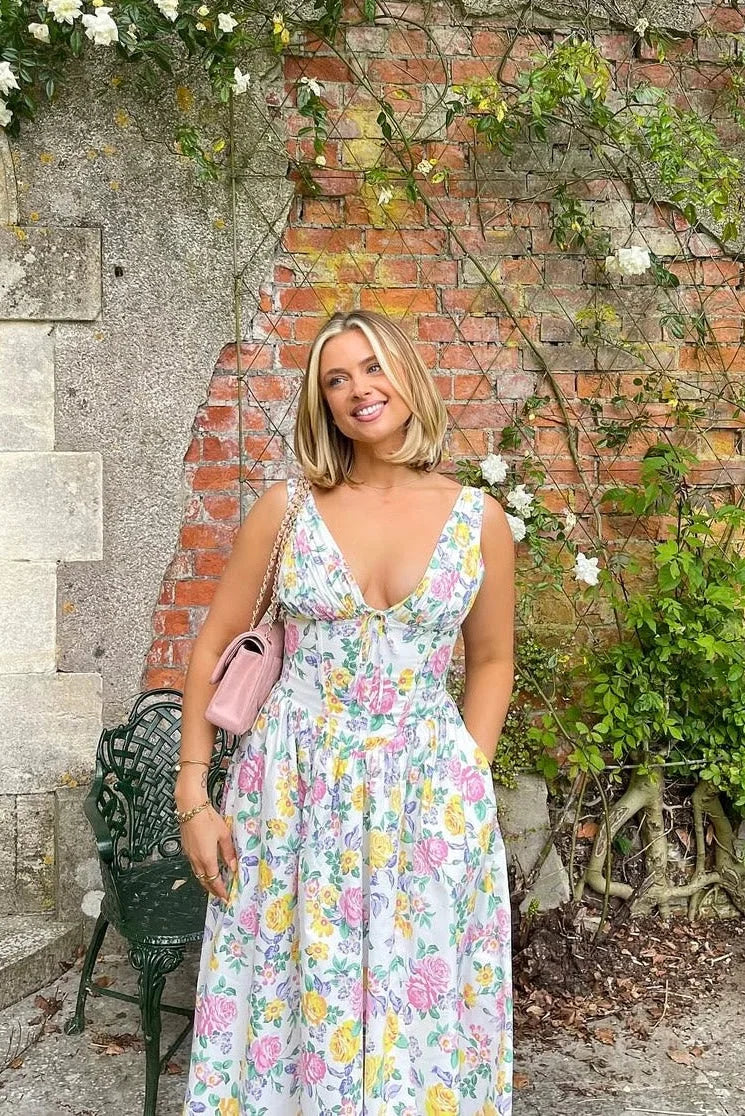Robe midi femme fleurie sans manches en coton blanc, avec un motif floral délicat et une coupe fluide.