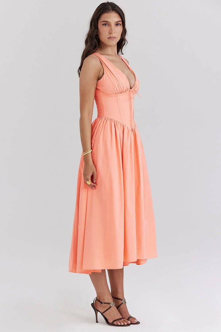 Robe midi femme fleurie sans manches en coton léger, avec un design floral et des couleurs pêche douces, parfaite pour l'été.