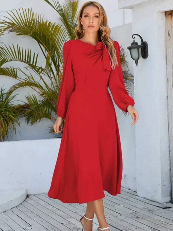 Robe midi bleue à manches longues avec nœud décoratif, en tissu léger, idéale pour des occasions décontractées.