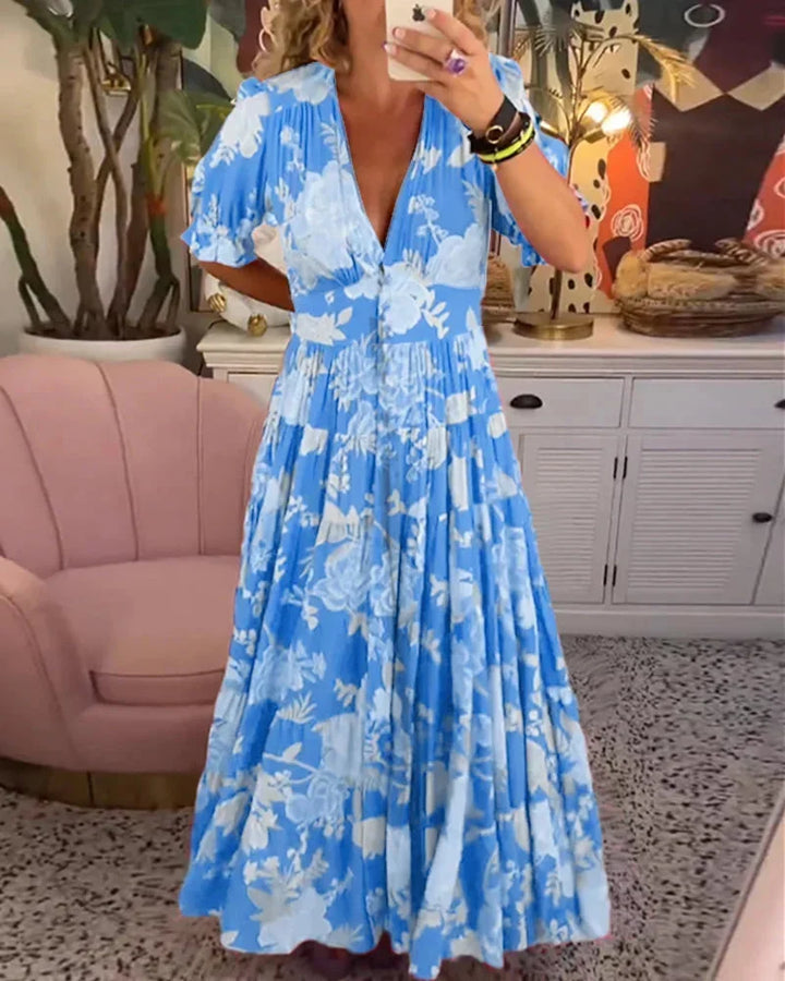 Robe midi bleue à motifs floraux, en coton léger, manches courtes et taille cintrée pour un look estival décontracté.