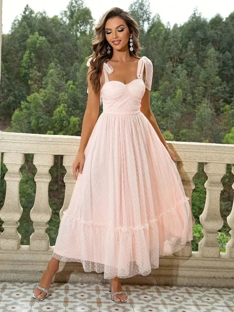 Robe midi sans manches en mesh, avec nœuds décoratifs sur les épaules, idéale pour l'été. Design léger et aérien.