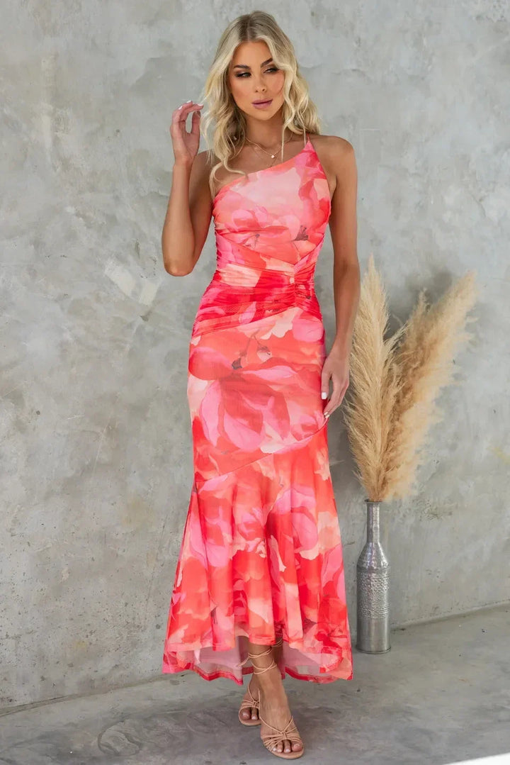 Robe midi sans bretelles en tissu fluide, motifs floraux, dos asymétrique, idéale pour un mariage d'été.