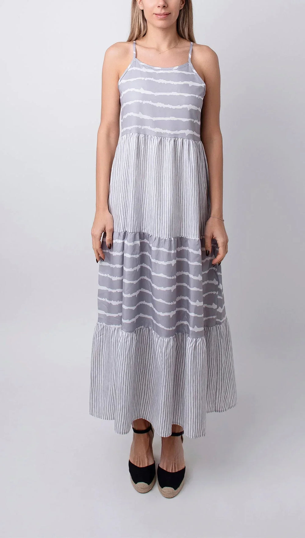 Robe midi grise sans manches, en coton léger, avec volants délicats pour une tenue estivale élégante et confortable.