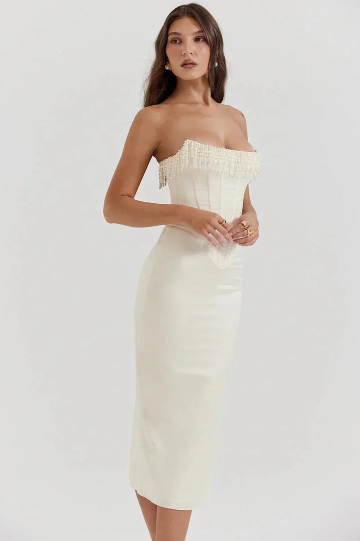 Robe midi ivoire avec bustier perlée et corset, en tissu satiné, idéale pour les soirées et cocktails élégants.