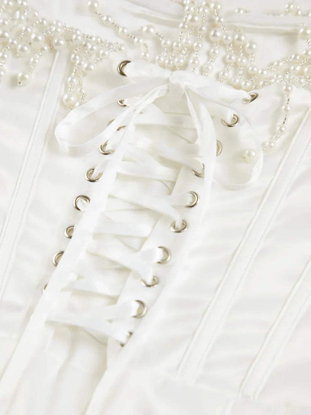 Robe midi ivoire en satin, bustier perlée et corset ajusté, idéale pour des soirées cocktails élégantes.
