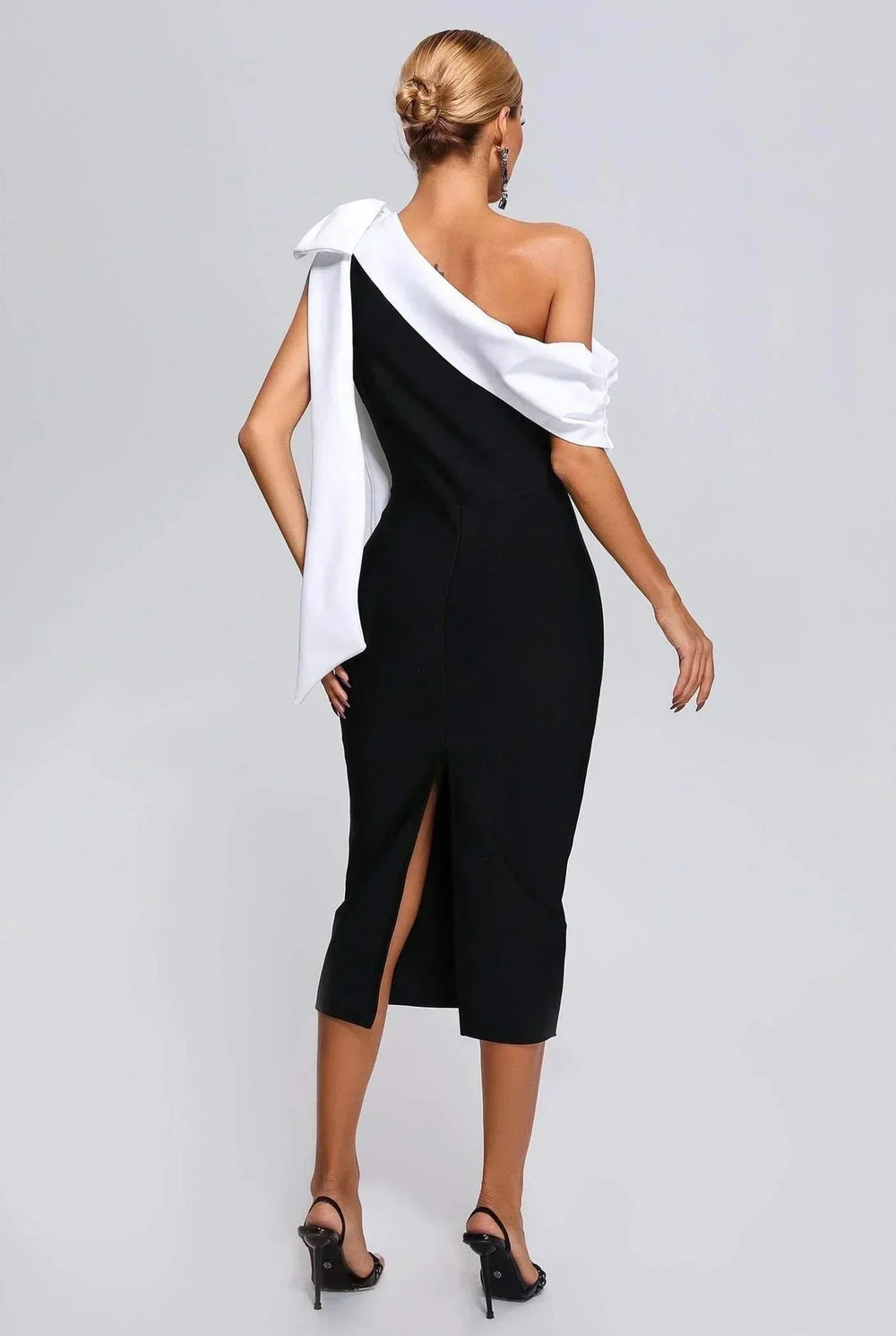 Robe midi noire et blanche, asymétrique à une épaule, en tissu léger avec nœud décoratif et coupe fluide.