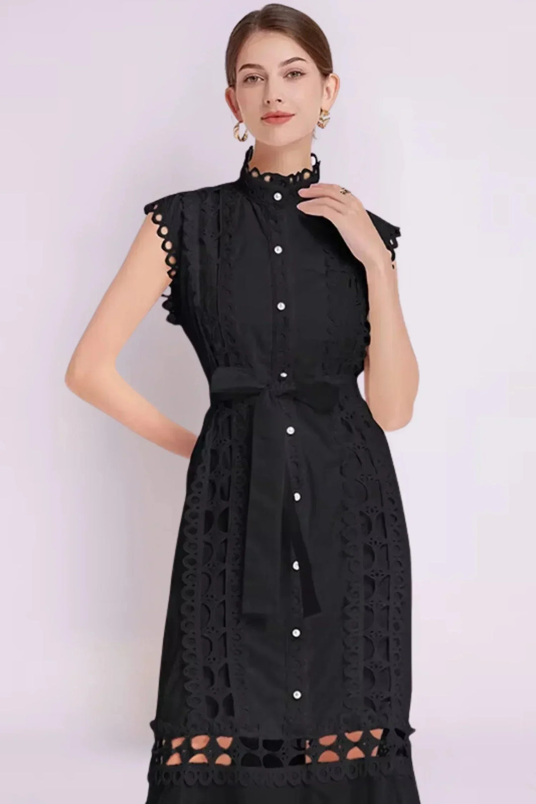 Robe midi noire sans manches en tissu léger, ornée de dentelle délicate et d'une ceinture ajustable pour un look élégant.