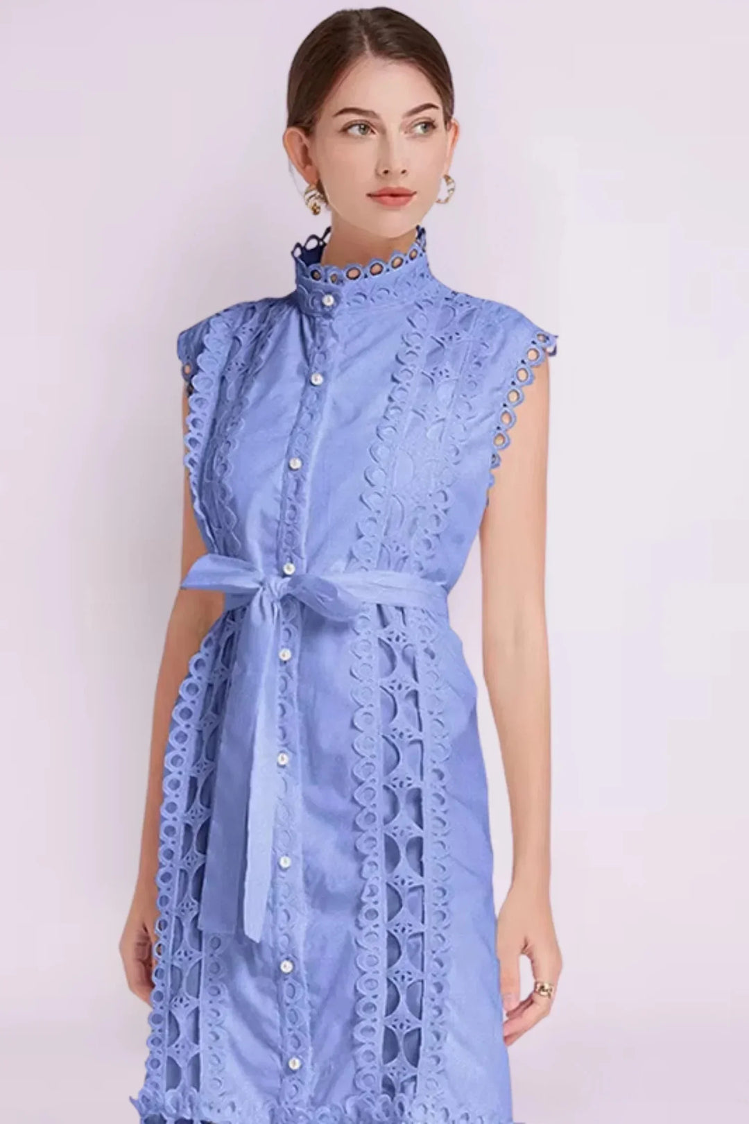 Robe midi noire sans manches en tissu léger, ornée de dentelle et accompagnée d'une ceinture pour une silhouette ajustée.