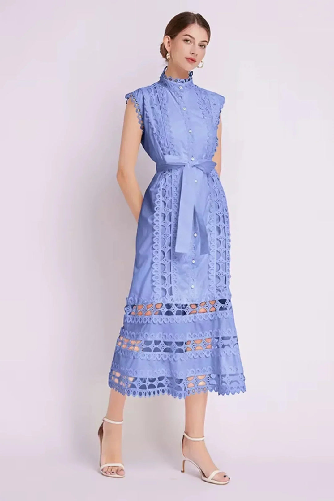 Robe midi noire sans manches en tissu léger, ornée de dentelle délicate et d'une ceinture ajustable à la taille.