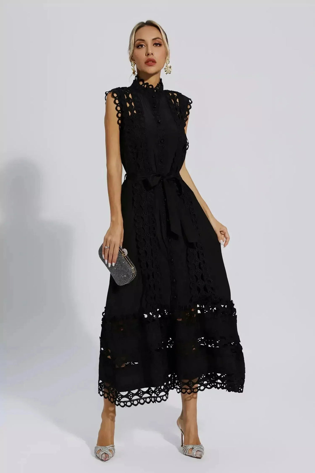 Robe midi noire sans manches en tissu léger, ornée de dentelle délicate et d'une ceinture ajustable à la taille.