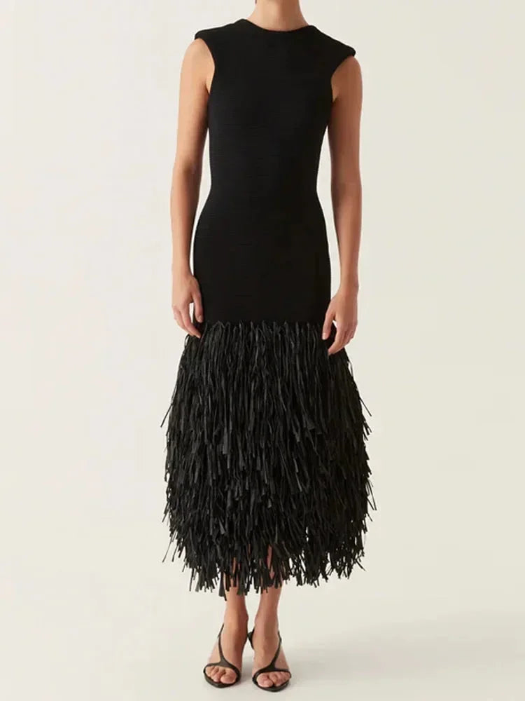 Robe midi noire sans manches avec des franges, confectionnée en tissu léger pour une soirée élégante.