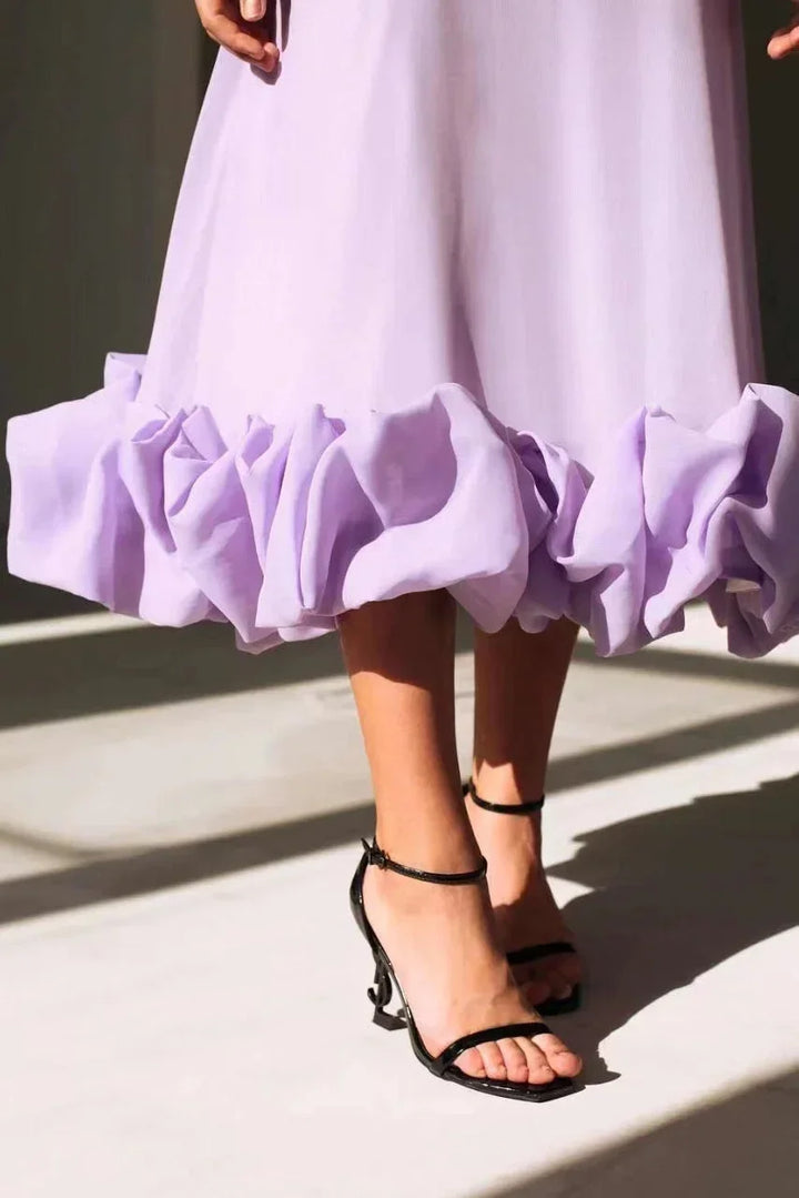 Robe midi unie sans manches avec volants, en tissu léger et fluide, idéale pour les soirées d'été.