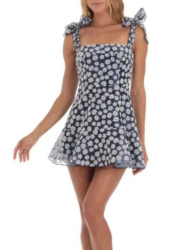 Robe courte A-ligne en tissu léger, ornée de dentelle et nœuds sur les épaules, idéale pour une soirée d'été.