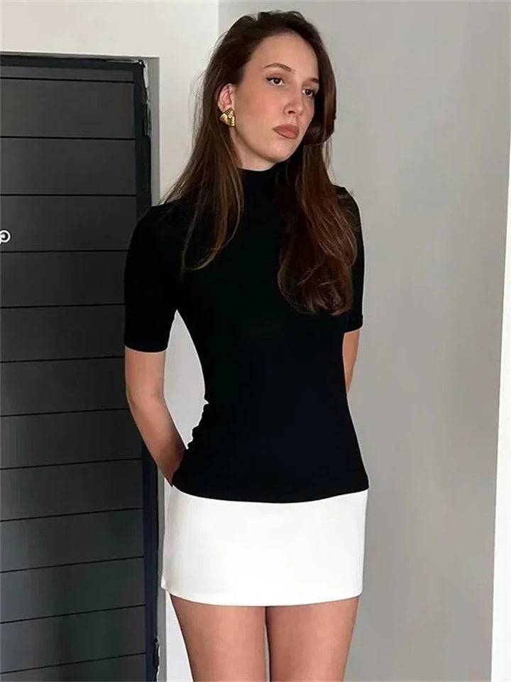 Robe courte bicolore bleu marine et blanc, col roulé, manches courtes, en matière légère pour un look décontracté.