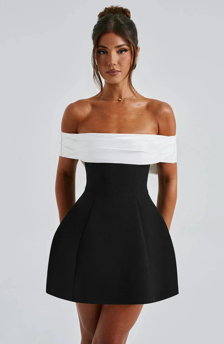 Robe courte bicolore en coton, épaules dénudées, avec un nœud blanc, parfaite pour les soirées. Design chic et confortable.