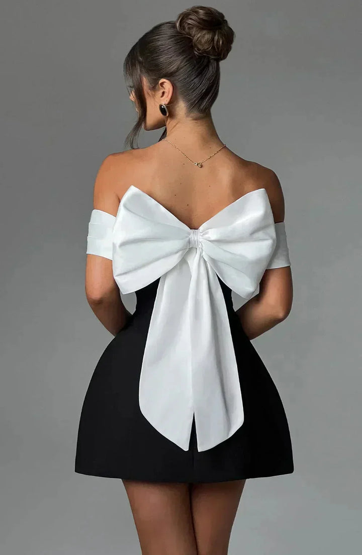 Robe courte bicolore avec épaules dénudées, nœud blanc, en tissu léger, idéale pour les soirées élégantes.
