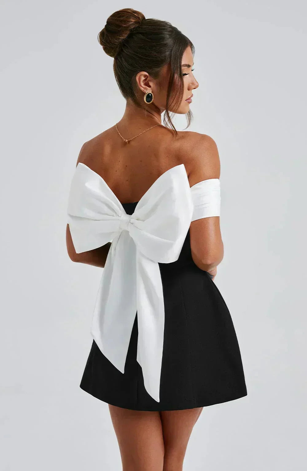 Robe courte bicolore avec épaules dénudées, nœud blanc, en tissu léger, parfaite pour les soirées estivales.