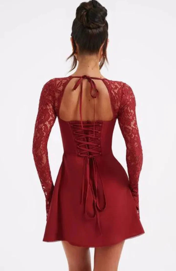 Robe courte blanche en dentelle avec manches longues et dos nu, coupe ajustée parfaite pour une soirée cocktail.