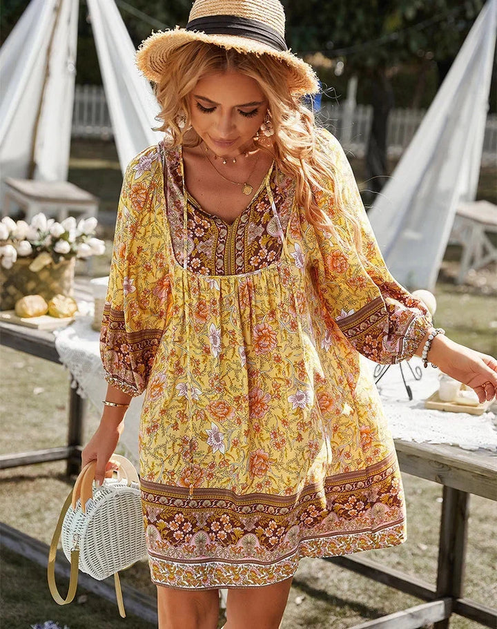 Robe courte bohème fluide avec imprimé coloré et manches longues, idéale pour un look décontracté estival.