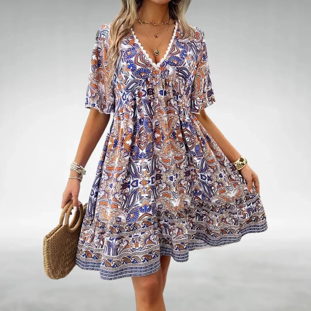 Robe courte bohème à motifs, avec col à cordon, légère et idéale pour la plage en été. Fabriquée en coton agrémenté.