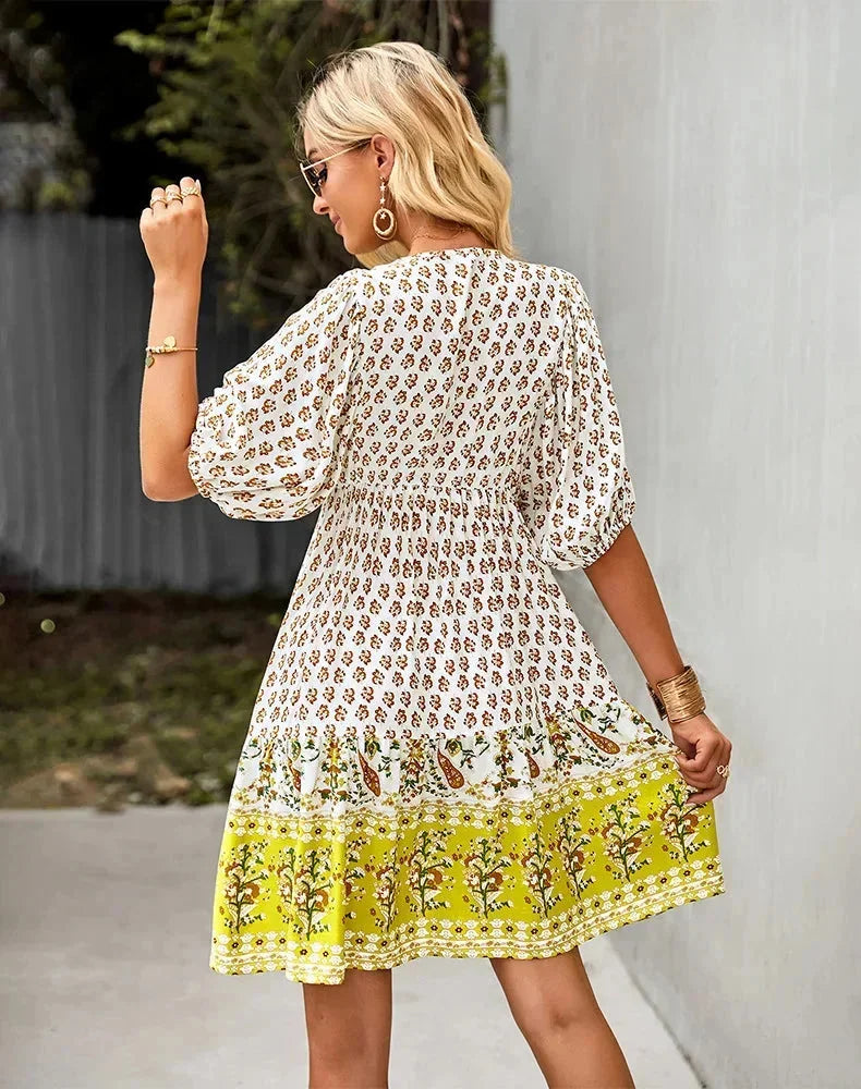 Robe courte bohème multicolore, col V, manches courtes élastiquées, en tissu léger idéal pour l'été et les journées à la plage.