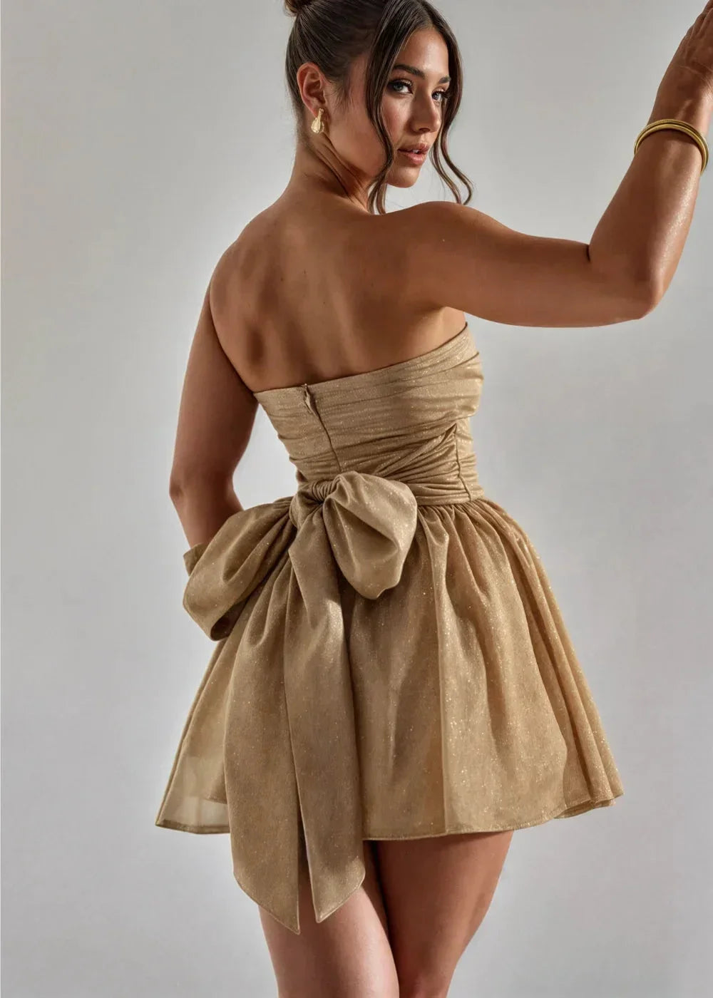 Robe courte bustier dos nu avec nœud, en tissu pailleté, idéale pour soirées et événements spéciaux.